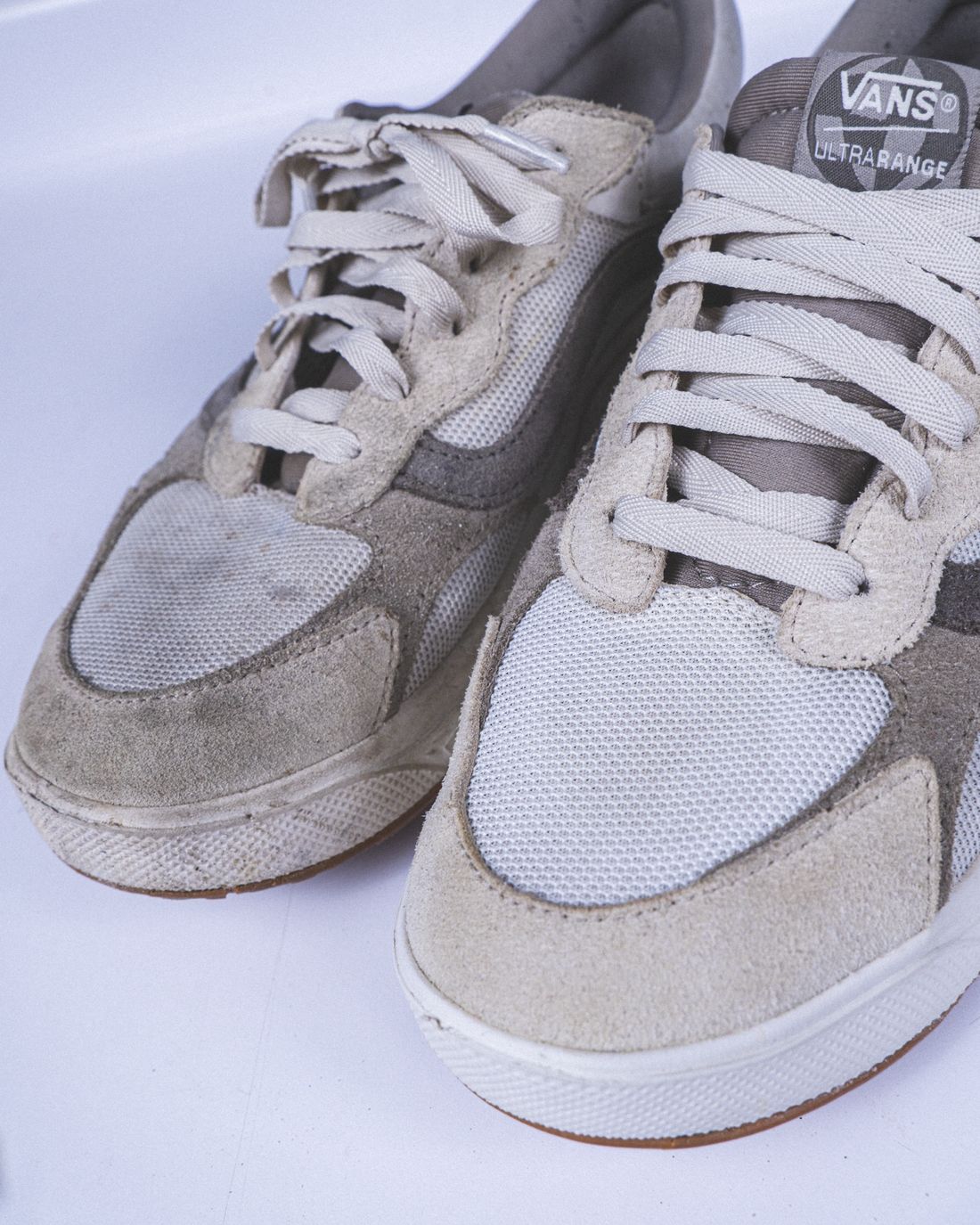 Un par de Vans UltraRange: el tenis izquierdo sucio y el derecho limpio después del servicio Premium